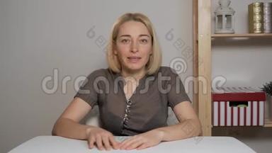 女博主坐在一张桌子旁，在网上商店里研究一次购买。